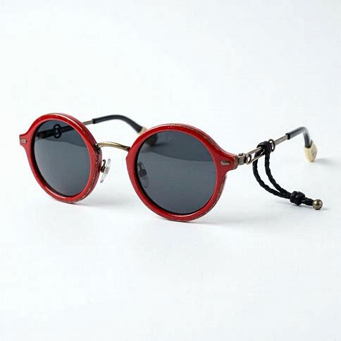 Round retro sunglasses with red frames and a beaded cord